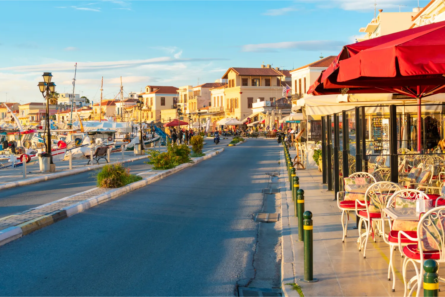 The Main Street Running Through The Picturesque Village Of Aegina With Shops And Cafes On One Side