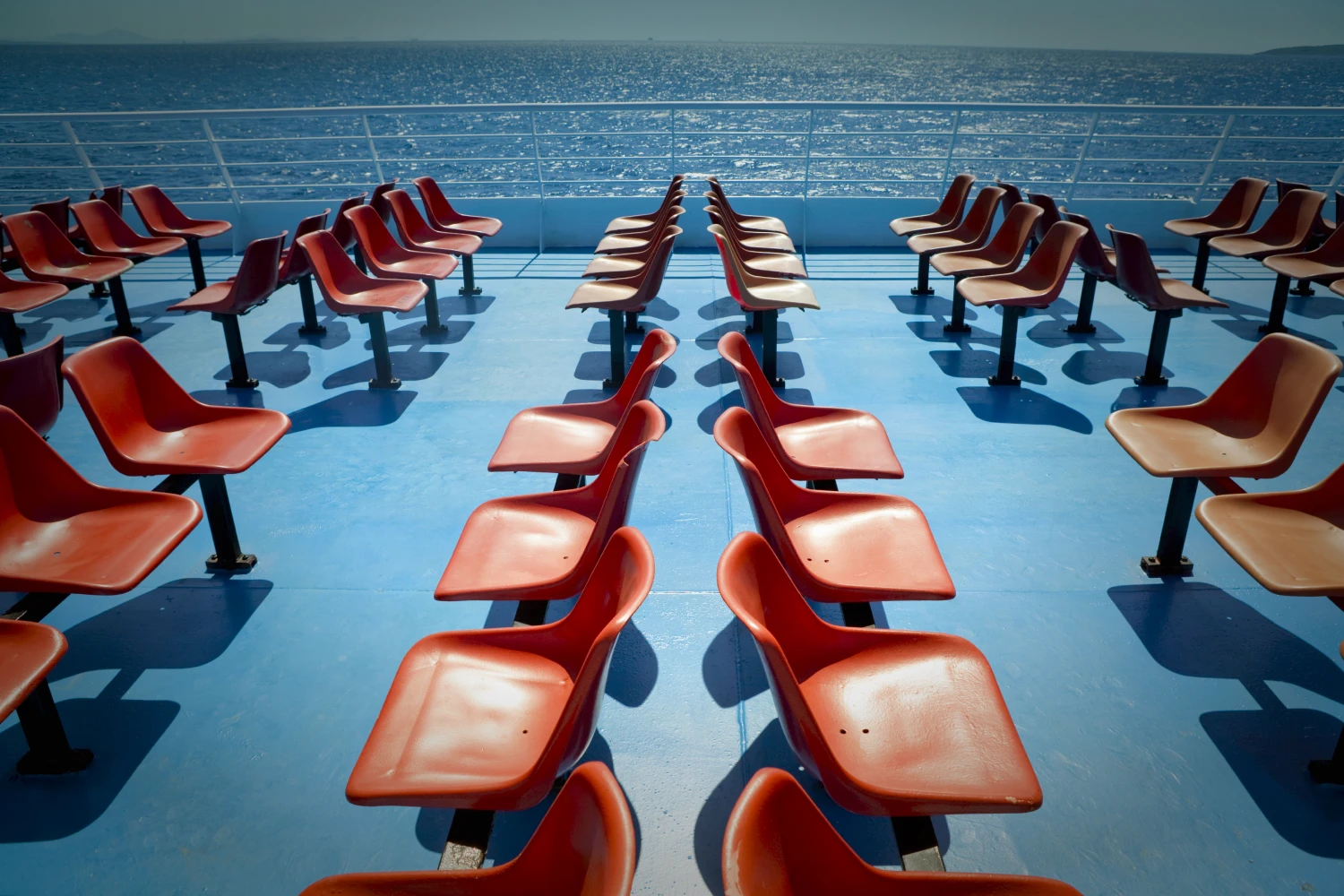 Empty orange deck seats on a ferry's open deck