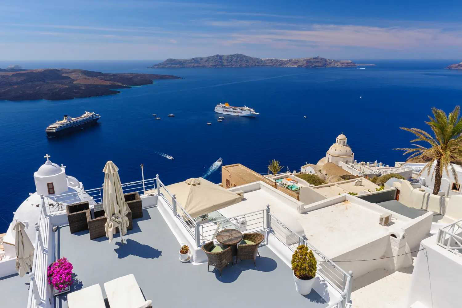 View of the caldera and cruise ships from a hotel's terrace