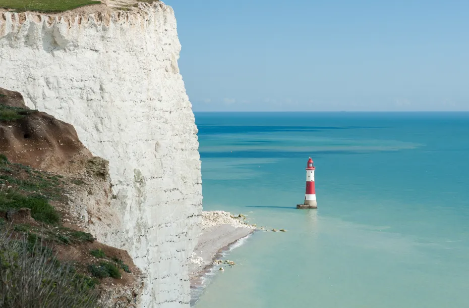 Amazing view of the Seven Sisters National Park with its white cliffs and white-red lighthouse in Dover, East Sussex, England