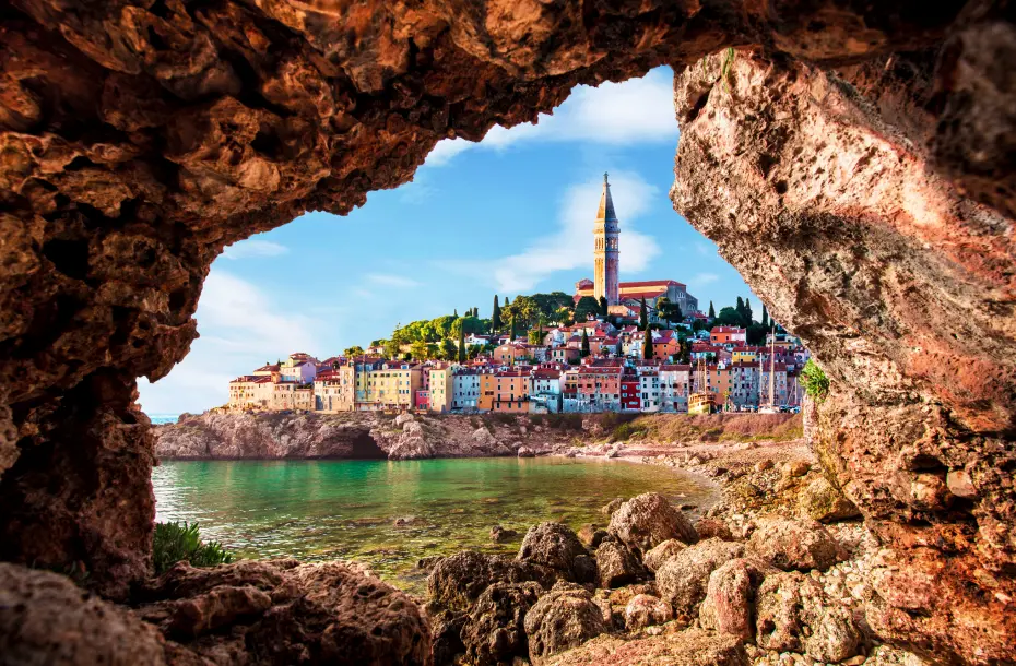 View of the old clock tower in Piran through a rock hole